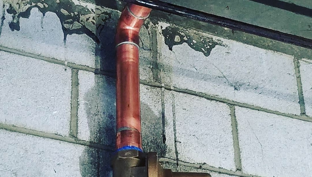 Copper pipes against an outside wall