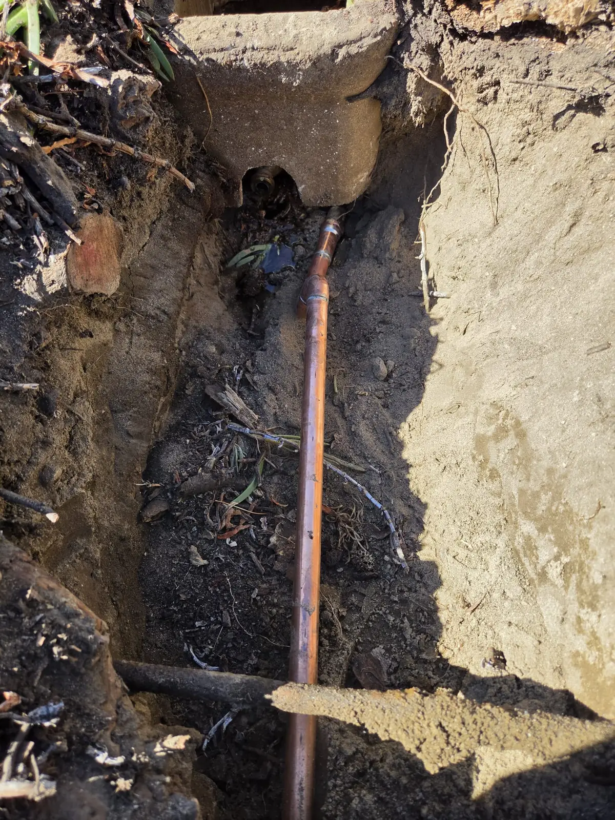 Copper main water line leak repair in an open trench